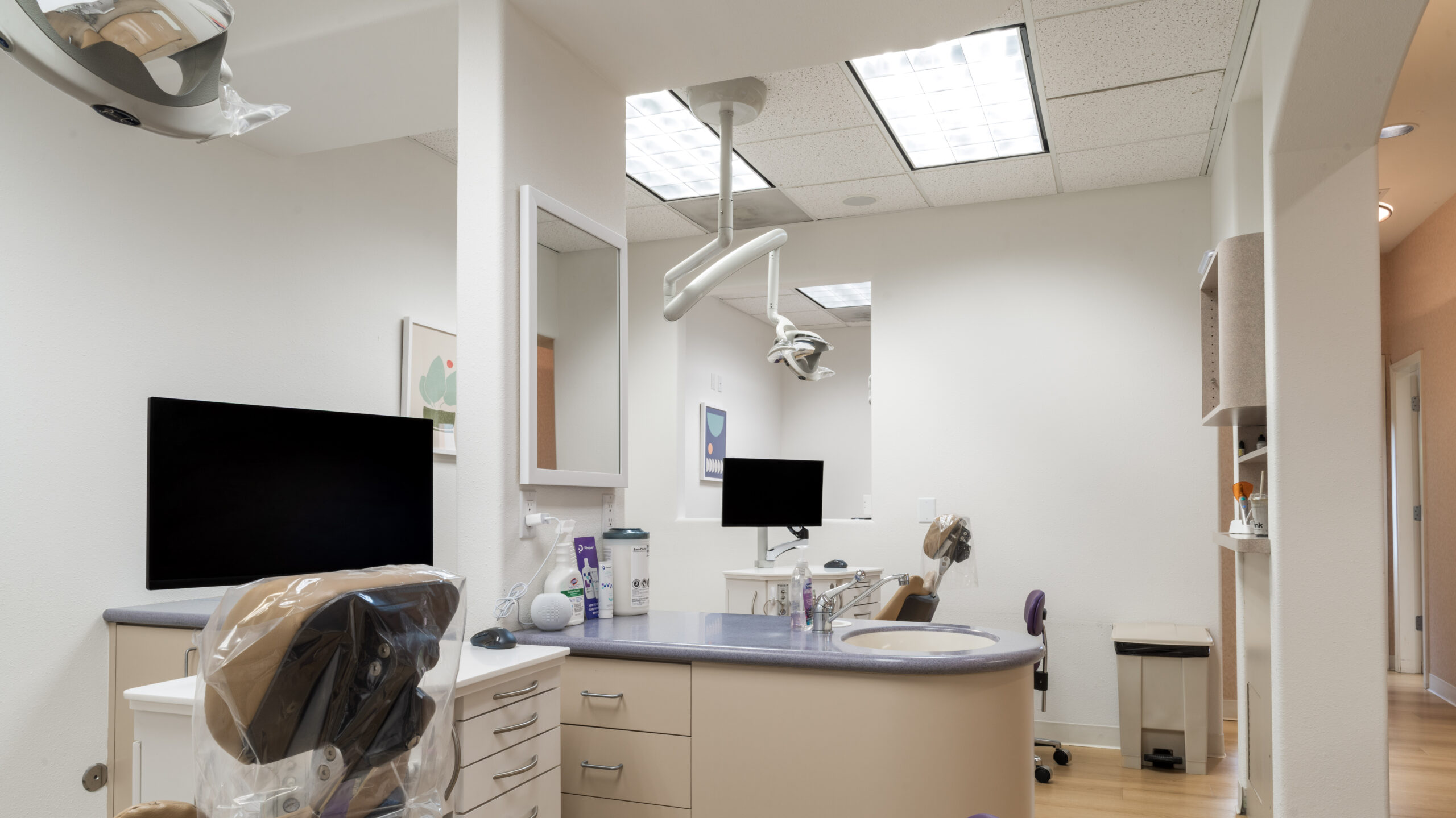 Modern treatment room at Keller & Wainwright Orthodontics in Sunnyvale, CA with dental chair and monitors
